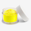 A small clear plastic jar filled with bright yellow food colouring powder, shown with its white lid leaning against it on a clean white background.