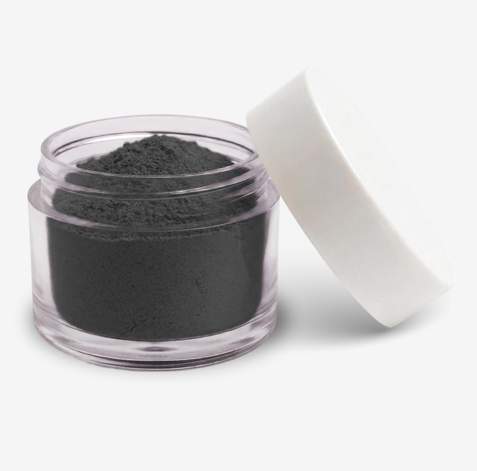 A small clear plastic jar filled with a black food colouring powder, with a white screw-on lid leaning against it on a clean white background.