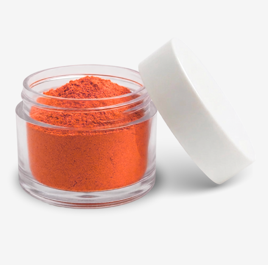 Orange food colouring powder in a clear round jar with a white lid leaning against it, photographed on a clean white background.
