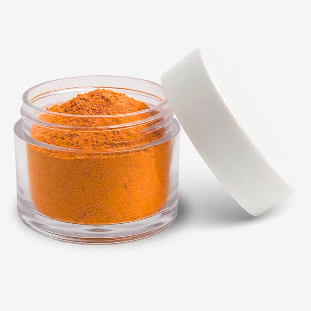 A small clear plastic jar filled with sunset orange food colouring powder, shown with its white lid leaning against it on a clean white background.